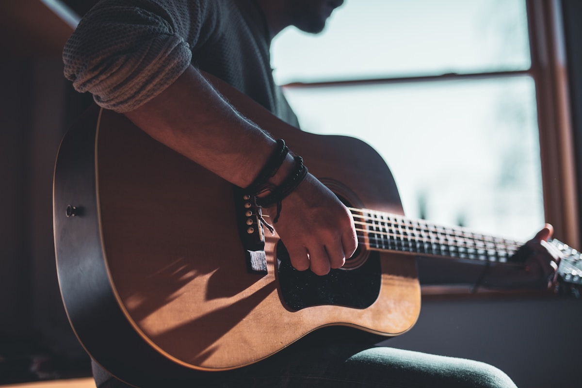 A person playing an acoustic guitar